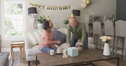 Senior Couple Celebrating Birthday with Cake and Gifts at Home
