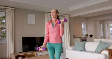 Senior Woman Exercising with Dumbbells in Cozy Living Room