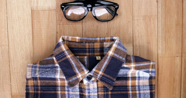 Folded Checkered Shirt with Black Glasses on Wooden Surface - Download Free Stock Images Pikwizard.com