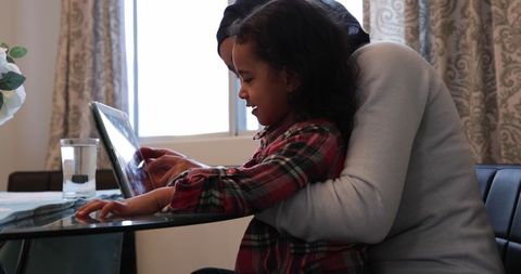 Biracial Mother and Daughter in Kitchen Using Tablet Together