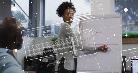 Businesswoman presenting data on flip chart with digital data overlays in modern office