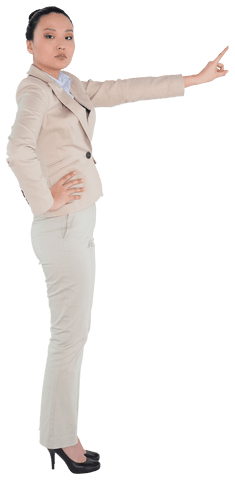 Asian businesswoman pointing upwards dressed in a beige suit. Can be used for presentations or promotional materials focused on leadership, determination, or professionalism themes. Ideal for business-related projects seeking ethnicity representation on a transparent background.