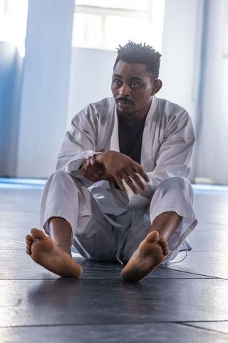Martial artist stretching in dojo for fitness and discipline