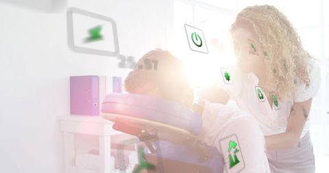 Therapist giving seated neck massage in wellness clinic with digital icons and sunlight