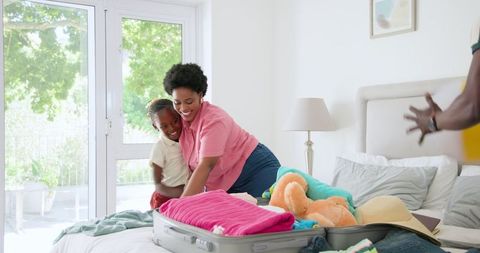 Family Packing Suitcases at Home for Vacation Preparation