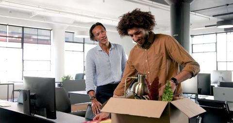 Diverse Colleagues Unpacking Office Belongings with Excitement