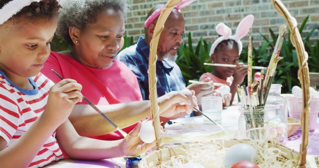 Happy african american grandparents and grandchildren decorating easter eggs in garden, slow motion - Download Free Stock Photos Pikwizard.com
