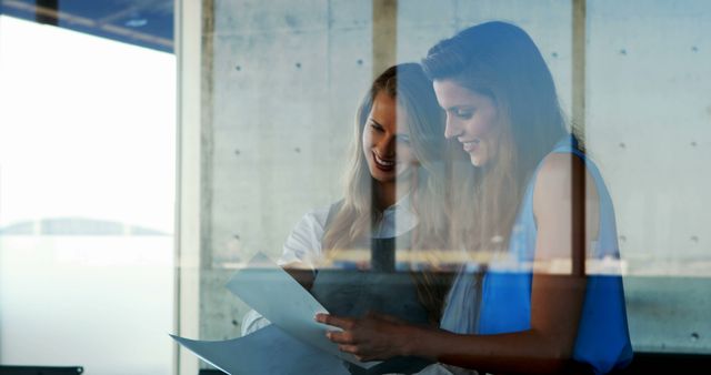 Businesswomen Discussing Documents through Transparent Window - Download Free Stock Images Pikwizard.com