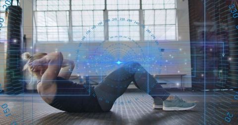Athlete doing abdominal crunches with futuristic HUD overlay in sunlit gym studio