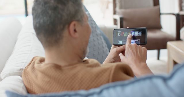 Man Relaxing on Sofa Using Smartphone Watching Videos - Download Free Stock Images Pikwizard.com