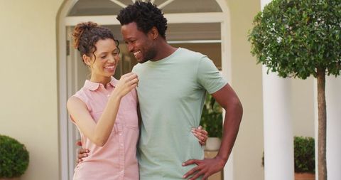 Happy biracial couple celebrating new home ownership outdoors