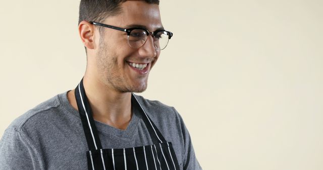 Smiling young chef wearing striped apron and glasses - Download Free Stock Images Pikwizard.com