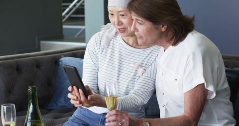 Senior Female Friends Celebrating with Champagne in Living Room