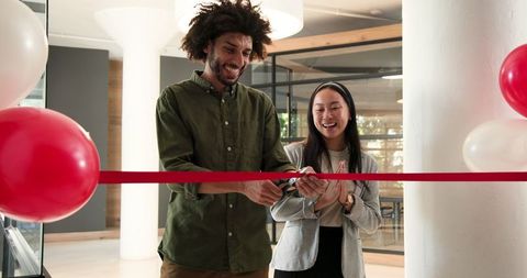 Business team celebrating new office opening with ribbon cutting ceremony