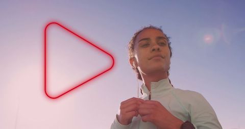 Confident Woman with Earphones and Neon Play Icon