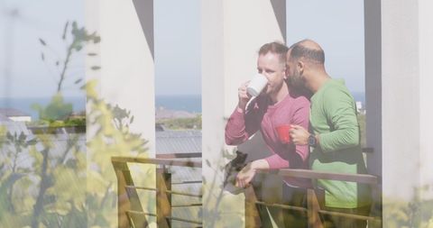 Couple Embracing on Balcony with Coffee Against Vista