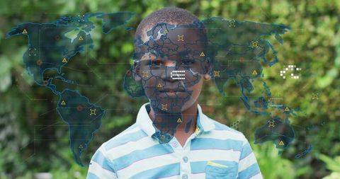 Boy standing in garden wearing striped polo with world map hud overlay, tech concept