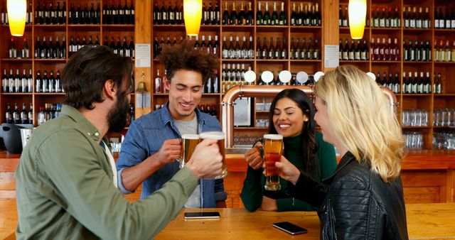 A group of friends are at a bar counter in a brewery, clinking their beer mugs and enjoying a pleasant time together. Perfect for concepts related to social gatherings, leisure activities, friendship, nightlife, and brewery promotions. Useful for advertisements, social media posts, blog articles on places to socialize or beer culture, and community event marketing.