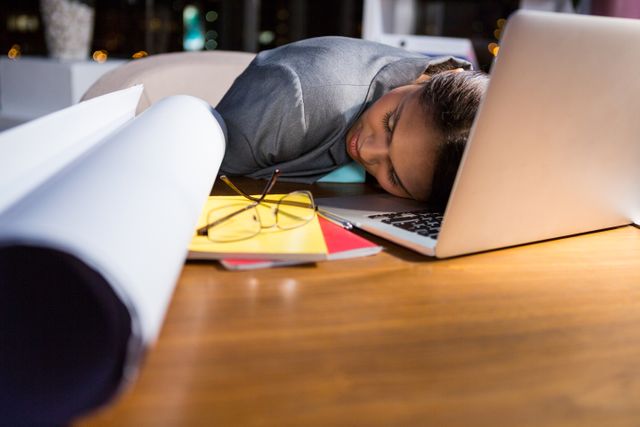 Businesswoman sleeping while working in office at night