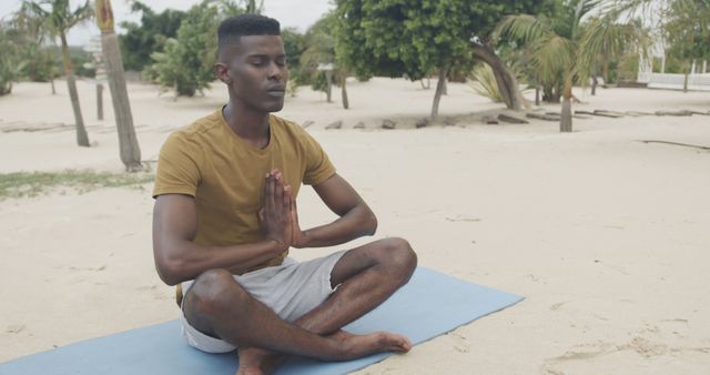 Man Meditating on Beach in Yoga Pose - Download Free Stock Images Pikwizard.com