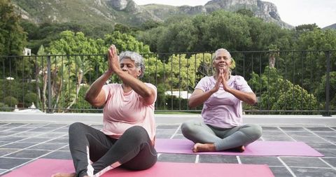 Senior African American Women Practicing Yoga on Balcony with Scenic Mountain View