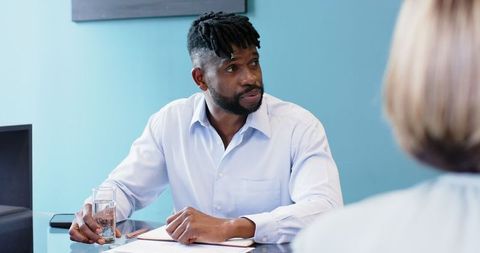 Businessman engaging in office meeting, emphasizing teamwork and hydration