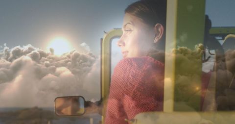 Woman in car with surreal cloudscape