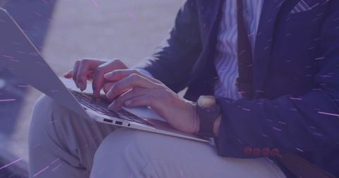Businessman Typing on Laptop in Outdoor Courtyard
