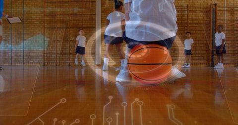 Elementary students practicing basketball with digital circuit overlay in school gym