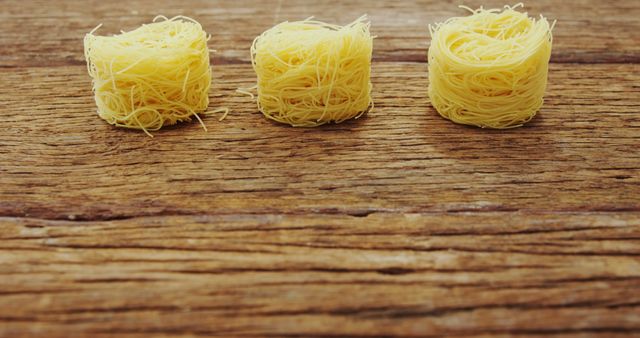 Three Nests of Dry Pasta on Rustic Wooden Table - Download Free Stock Images Pikwizard.com