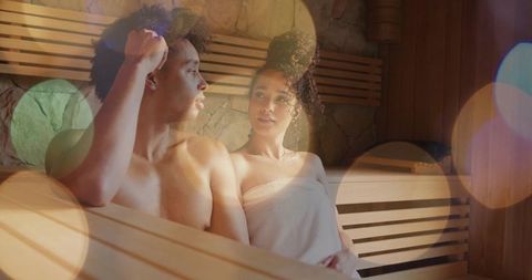 Couple relaxing on wooden sauna bench, intimate spa wellness, steamroom ambience
