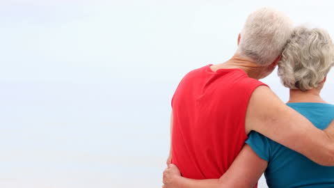 Senior Couple Embracing on Beach: Serene and Timeless Scene