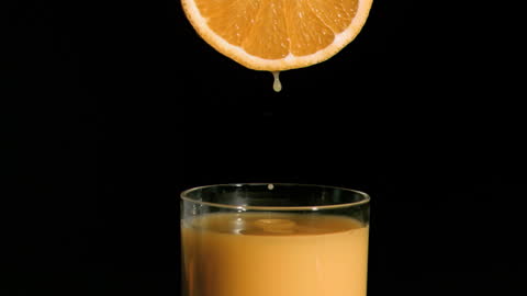 Fresh Orange Juice Dropping from Sliced Fruit