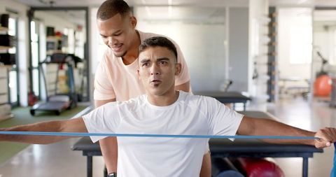 Physical Therapist Assisting with Resistance Band Exercise in Clinic