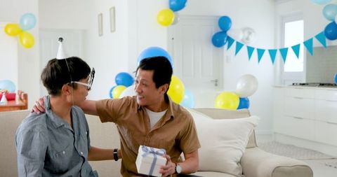 Father and son celebrating birthday with joyful moments at home