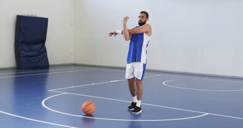 Basketball Player Stretching on Indoor Court for Practice