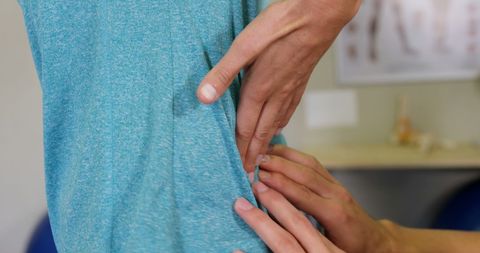Therapist performing back examination in clinic setting