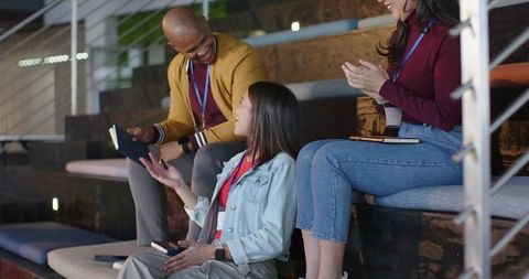 Diverse Professionals Collaborating in Modern Lounge Using Notebooks and Mobile Devices