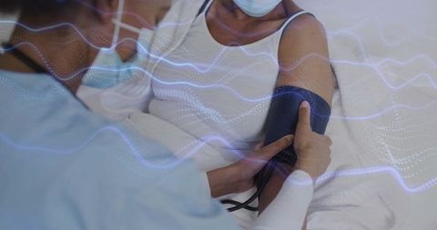 Nurse monitoring blood pressure in hospital setting