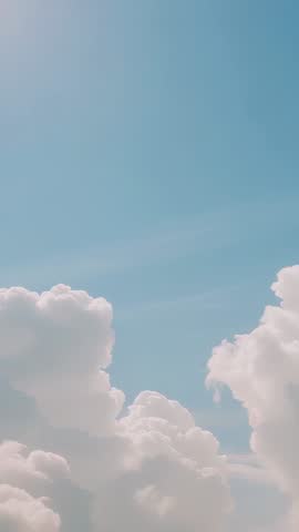 Drifting cumulus clouds reshaping over expansive blue sky | Vertical cloudscape for mobile