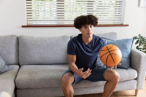 Young Man Relaxing Watching Basketball Games at Home