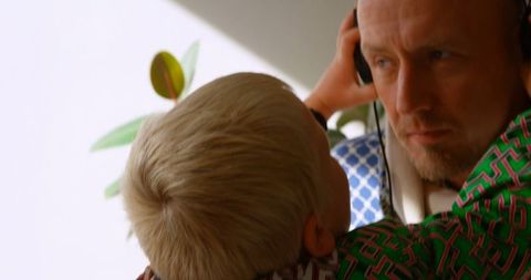Father and Children at Home Sharing Music on Headphones