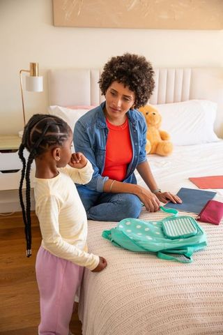 Mother and daughter organizing school supplies with teddy bear decoration