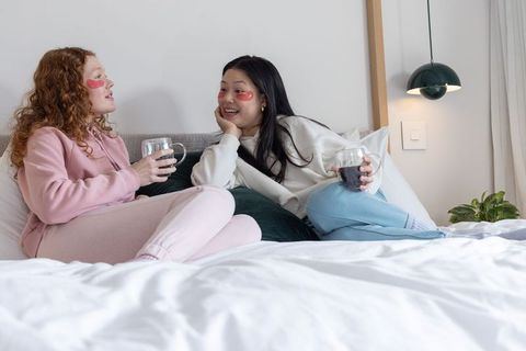 Relaxing self-care night with friends wearing under-eye patches and sipping drinks