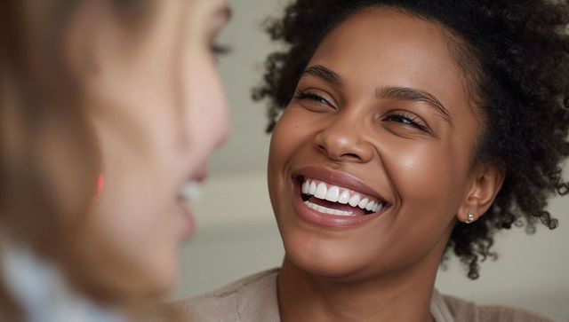 Radiant laughing woman facing friend closeup, candid joyful smile for lifestyle campaigns