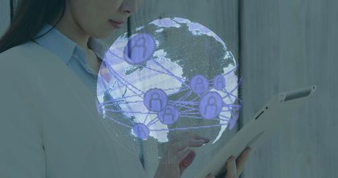 Businesswoman using tablet with holographic globe and connectivity icons