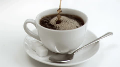 Slow Motion Coffee Pour into Cup with Sugar Cubes