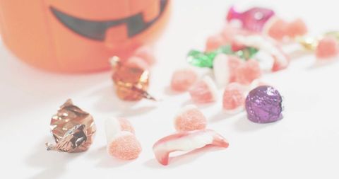 Pastel halloween candy spread with jack-o-lantern bucket, gumdrops and gummies