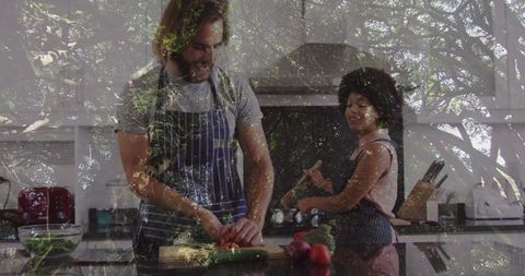 Couple cooking and chopping vegetables in modern kitchen
