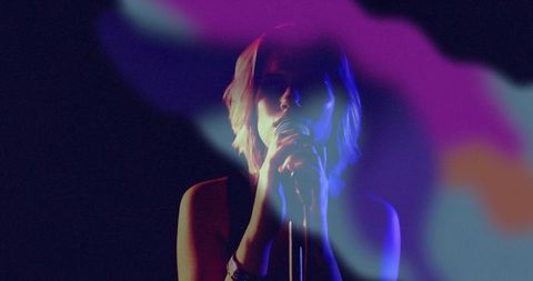 Teen Singer Performing on Stage with Colorful Haze